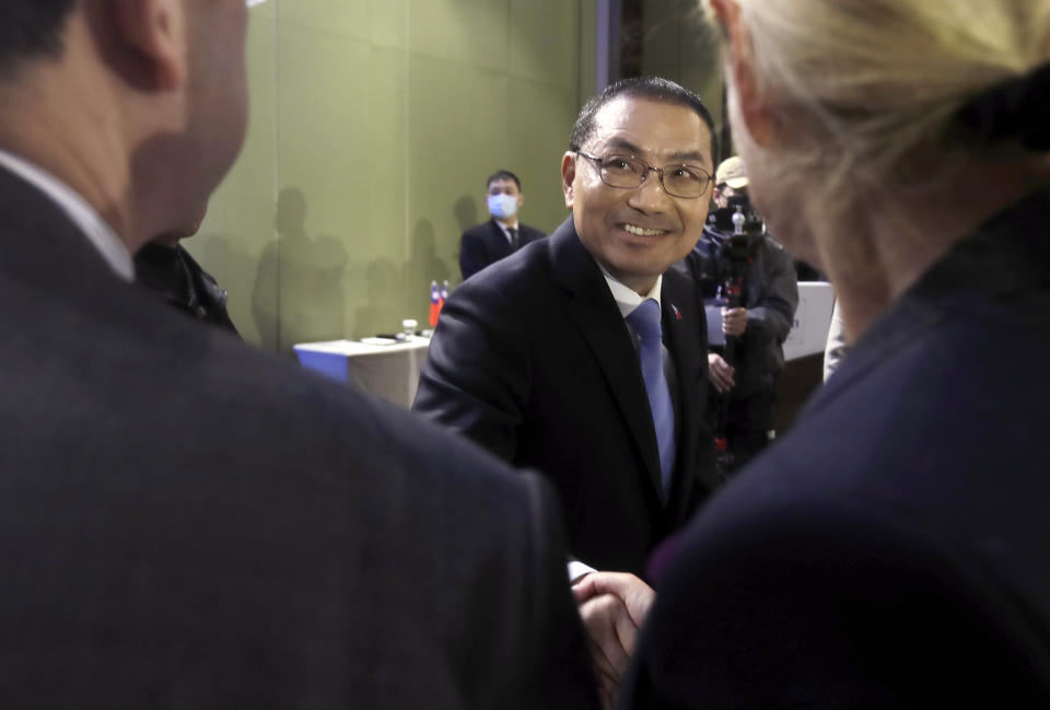 Taiwan's Nationalist Party presidential candidate Hou Yu-ih, center, shakes hands with reporters during an international press conference in New Taipei, Taiwan, Thursday, Jan. 11, 2024. Taiwan will hold its presidential election on Jan. 13. (AP Photo/Chiang Ying-ying)