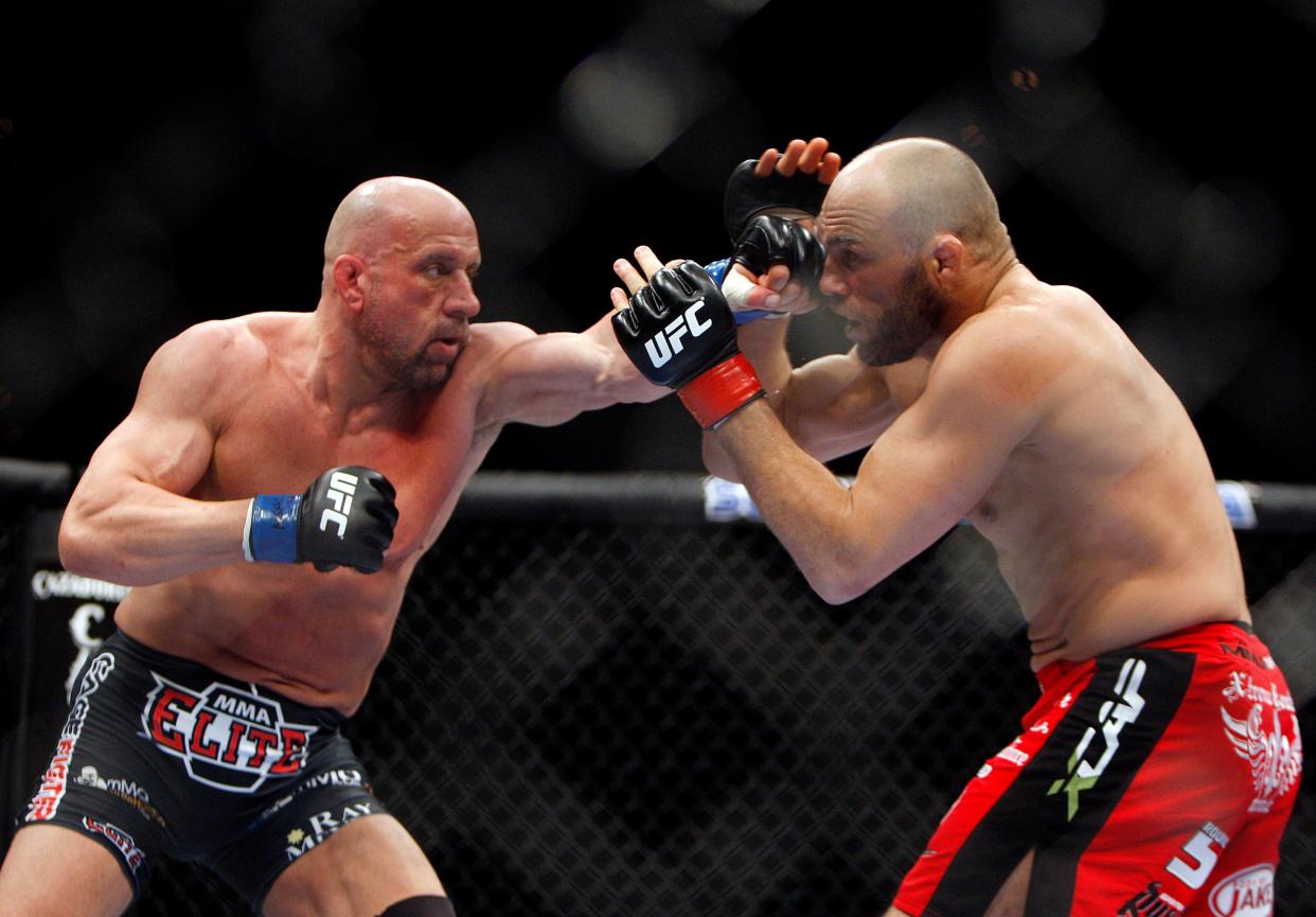 Mark Coleman, left, punches Randy Couture during their mixed martial arts light heavyweight bout Saturday, Feb. 6, 2010 in Las Vegas. (AP Photo/Isaac Brekken)