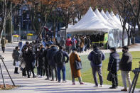 People queue in line to wait for the coronavirus testing at a makeshift testing site in Seoul, South Korea, Wednesday, Nov. 24, 2021. New coronavirus infections in South Korea exceeded 4,000 in a day for the first time since the start of the pandemic as a delta-driven spread continues to rattle the country after it eased social distancing in recent weeks to improve its economy. (AP Photo/Ahn Young-joon).