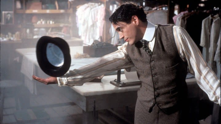 A man balances a hat on his arm in Chaplin.