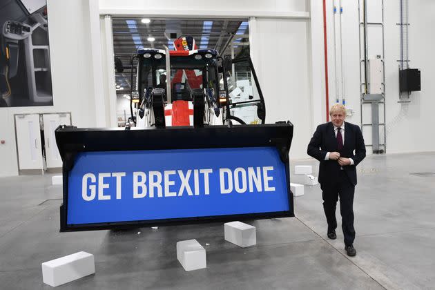 Prime Minister Boris Johnson walks away after driving a Union flag-themed JCB, with the words