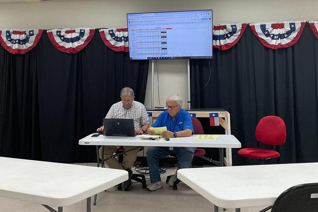 Bruce Campbell and Jim Riley sitting at a table reviewing precinct vote totals.