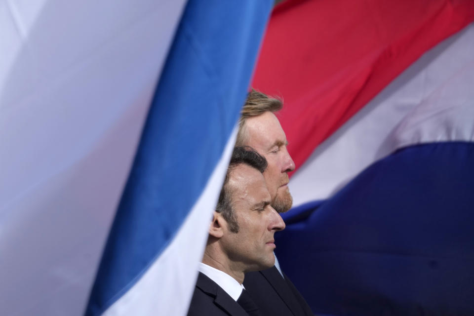 French President Emmanuel Macron, left, and Dutch King Willem-Alexander listen to national anthems outside the royal palace on Dam square in Amsterdam, Netherlands, Tuesday, April 11, 2023. French President Emmanuel Macron begins a two-day state visit to the Netherlands on Tuesday and is making a speech on his vision for the future of Europe. (AP Photo/Peter Dejong)