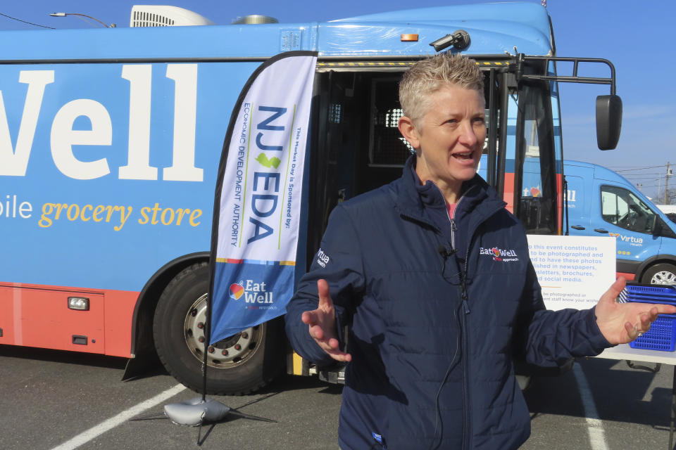 April Schetler, who runs a new program to bring nutritious food and produce to low-income neighborhoods in Atlantic City, N.J. speaks outside a specially modified bus that serves as a mobile supermarket in Atlantic City N.J. on Friday, Dec. 8, 2023. Virtua Health and the New Jersey Economic Development Authority are operating a service to bring fresh groceries and produce to Atlantic City, where plans for what would be the city's first supermarket in nearly 20 years recently fell through. (AP Photo/Wayne Parry)