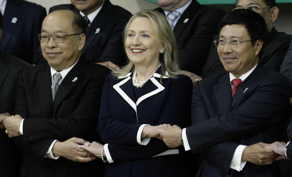 U.S. Secretary of State Hillary Rodham Clinton, center, shakes hands with her counterparts Pham Binh Minh, right, of Vietnam, and Surapong Tovichakchaikul, left, of Thailand during the photo session of the ASEAN-U.S. Ministerial Meeting in Phnom Penh, Cambodia, Thursday, July 12, 2012. (AP Photo/Heng Sinith)