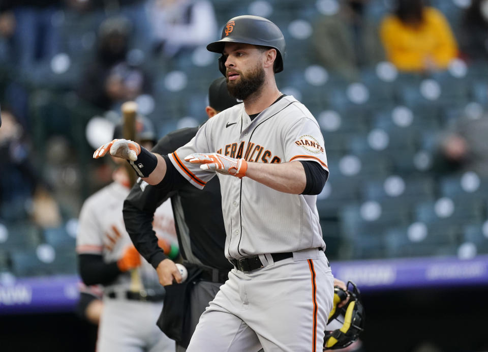 San Francisco Giants' Brandon Belt crosses home plate after hitting a two-run home run against the Colorado Rockies in the first inning of game two of a baseball doubleheader Tuesday, May 4, 2021, in Denver. (AP Photo/David Zalubowski)