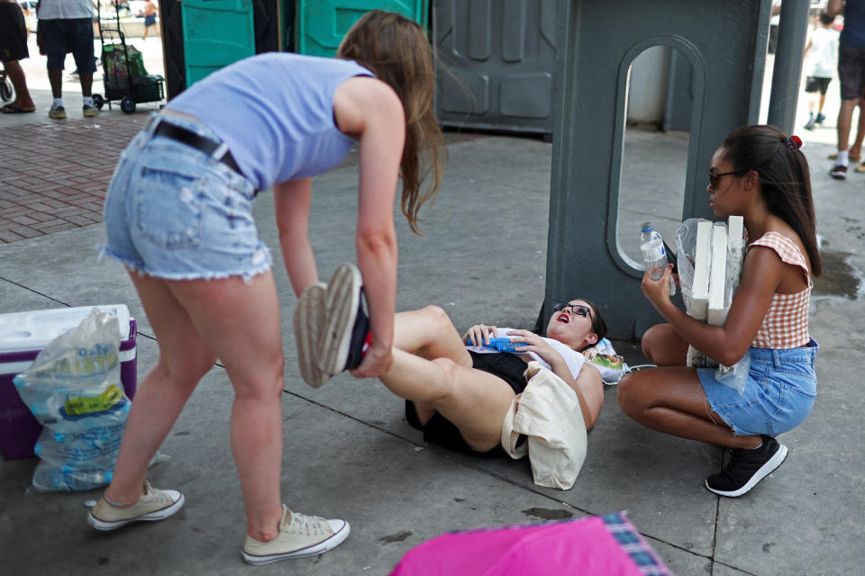 Image: A girl feels sick from high temperatures as she waits outside the stadium for a concert (Pilar Olivares / Reuters via Redux)