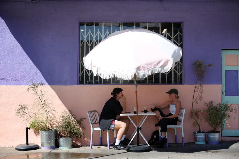 LOS ANGELES, CA - OCTOBER 13: Annalise Gehling, left, and Quincie Bean, right, eat at Cafe Tropical in Silverlake on Tuesday, Oct. 13, 2020 in Los Angeles, CA. More unseasonably warm weather is on tap for California this week, with officials warning that a combination of high temperatures and gusty winds will heighten fire danger throughout much of the state. (Dania Maxwell / Los Angeles Times)