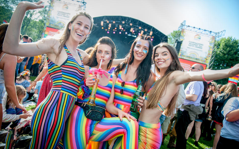 Four women in rainbow outfits have fun at Pride