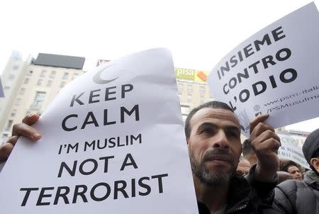 A man holds a placard during demonstration called "Not in my name" of Italian muslims against terrorism, in downtown Milan, Italy, November 21, 2015. REUTERS/Alessandro Garofalo