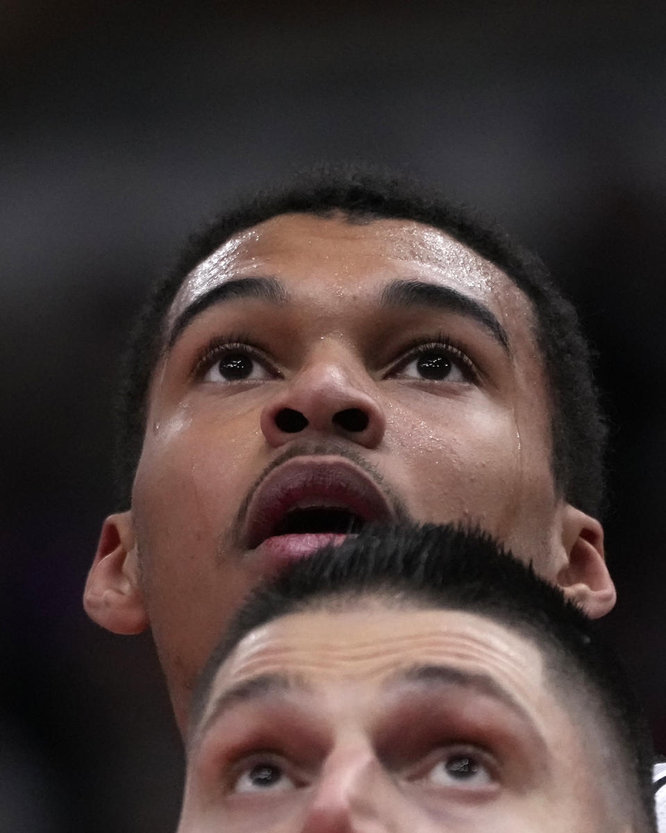 San Antonio Spurs' Victor Wembanyama, top,, looks over Chicago Bulls' Nikola Vucevic, bottom, for a rebound during the first half of an NBA basketball game Thursday, Dec. 21, 2023, in Chicago. (AP Photo/Charles Rex Arbogast)