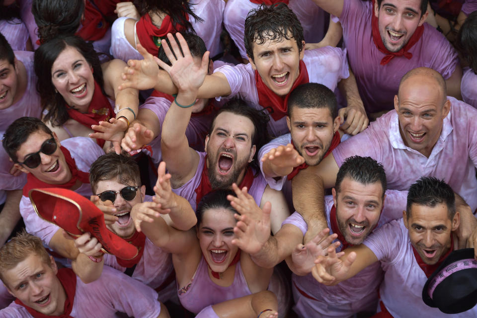 <p>Revellers beg for buckets of water is to be thrown over them from people on balconies during the launch of the ‘Chupinazo’ rocket, to celebrate the official opening of the 2018 San Fermin fiestas with daily bull runs, bullfights, music and dancing in Pamplona, Spain, Friday July 6, 2018. (Photo: Alvaro Barrientos/AP) </p>