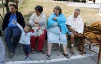 People sit along a road following an earthquake in Amatrice, central Italy, August 24, 2016. REUTERS/Ciro De Luca