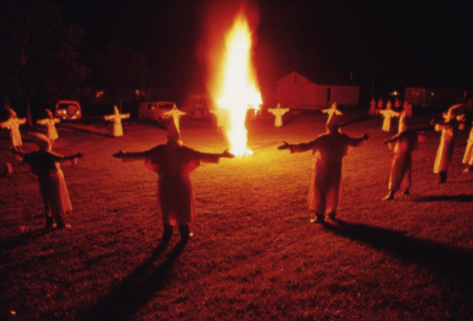 <p>Klansmen form a circle around a burning cross in 1990. Their arms spread wide symbolize the association of each member among the fraternal circle, a large family of brothers and sisters. (Photo: Eric-Paul-Pierre Pasquier/Gamma-Rapho via Getty Images) </p>