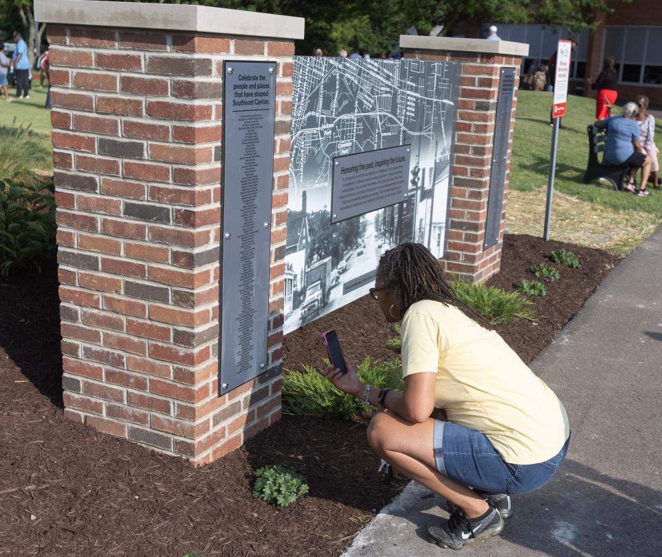 Teresa Young-Fite takes photos of the names of people, churches and businesses that shaped southeast Canton on a tribute wall at the Southeast Community Playground.