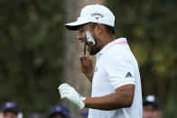 Xander Schauffele bites his club after taking his second tee shot on the 16th hole during the final round of the Masters golf tournament on Sunday, April 11, 2021, in Augusta, Ga. His first tee shot went into the water. (AP Photo/Charlie Riedel)