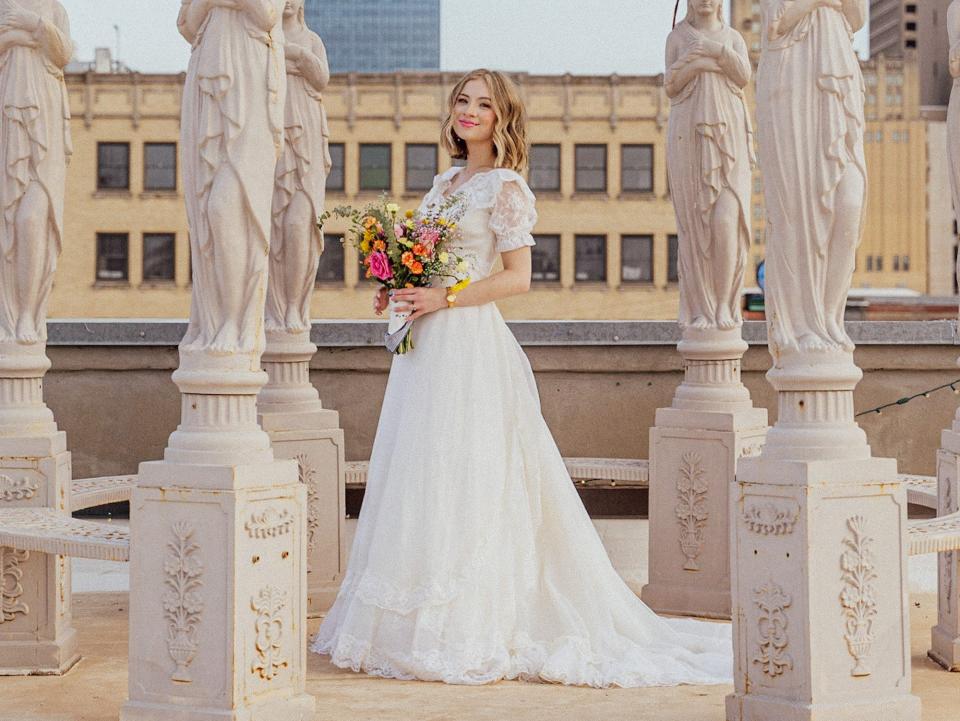 A bride stands under a gondola.