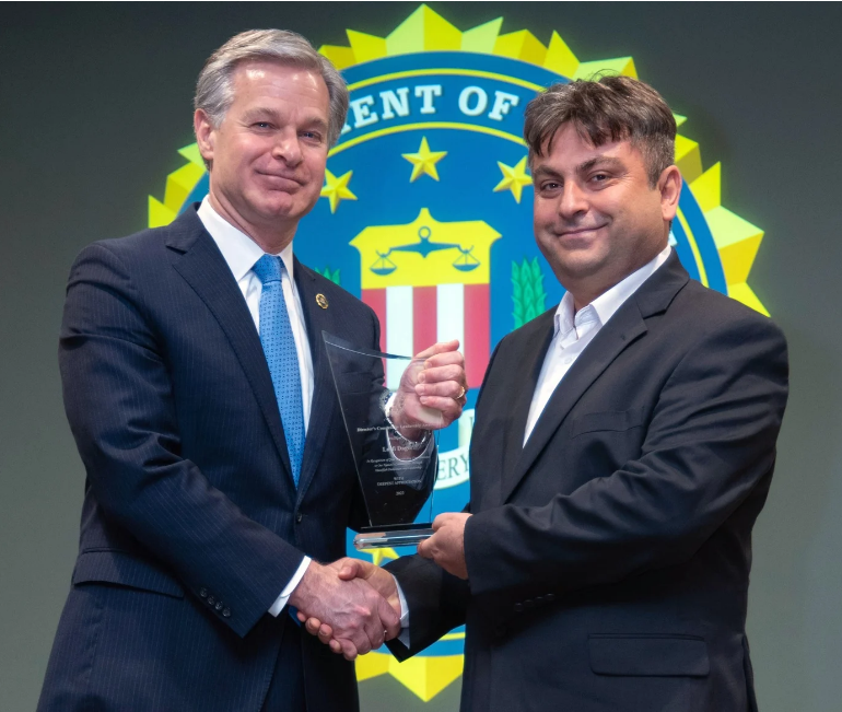 FBI Director Christopher Wray, left, presents Lutfi Dagci, director of the Raindrop Turkish House, Dialogue Institute of El Paso, with the FBI Director’s Community Leadership Award for 2023.