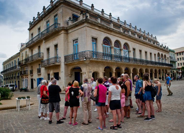 Tourists listen to a tourist guide in Havana, Cuba, on January 22, 2015