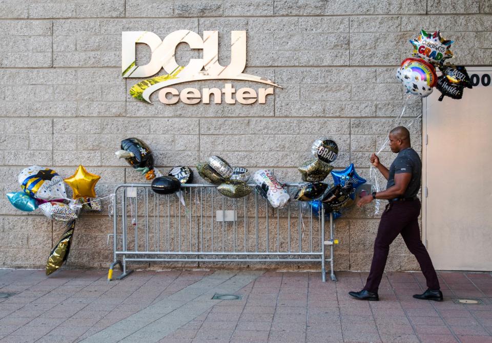 Sergio Prensa leaves his balloons outside the DCU Center as he arrives to see his daughter Nashla Prensa graduate from Burncoat High School Wednesday. The center does not allow balloons inside. Burncoat is the first of the city schools to hold commencement at the DCU Center.