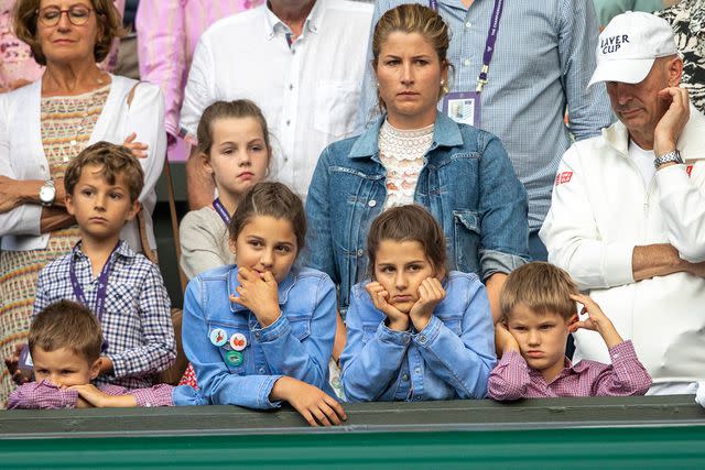 <p>Tim Clayton/Corbis via Getty</p> Mirka Federer and the kids at Wimbledon in 2019