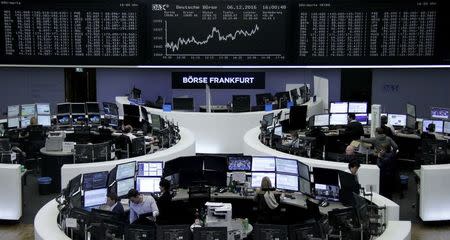 Traders work at their desks in front of the German share price index, DAX board, at the stock exchange in Frankfurt, Germany, December 6, 2016. REUTERS/Staff/Remote