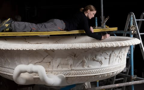 A restorer works on an ancient Roman basin - Credit: Torlonia Foundation