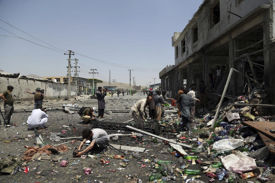 Journalists record the scene at the site of a suicide attack in Kabul, Afghanistan, Thursday, July 25, 2019. Three bombings struck the Afghan capital on Thursday, killing at least eight people, including five women and one child, officials said Thursday. (AP Photo/Rahmat Gul)