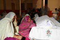 Pakistani mourners gather around the body of a victim, one of at least 19 killed in the earthquake that hit northeastern Pakistan