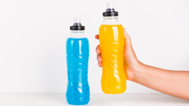 Blue and yellow sports drink bottles with hand