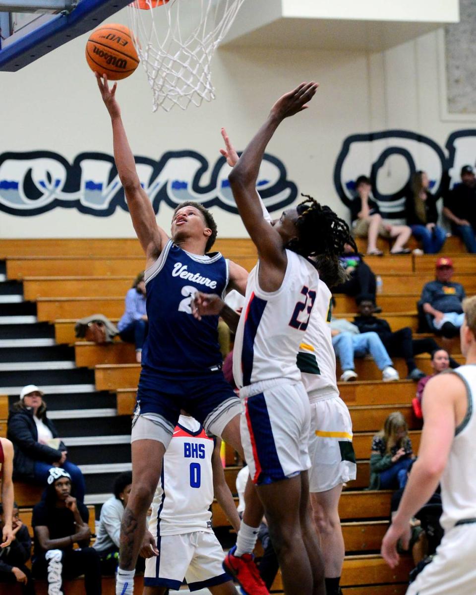 Venture Academys Mario Williams (20) goes up for a layup over Modesto Christians Drevon Johnson during the 27th Annual Six County All Star Senior Basketball Classic Boys game at Modesto Junior College in Modesto California on April 27, 2024. The Red team beat the Blue team 81-79.