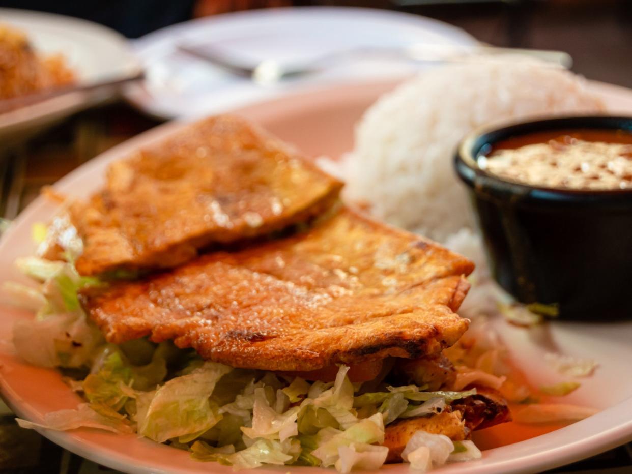 A steak Jibarito sandwich with white rice and beans on the side. Puerto Rican food cuisine.