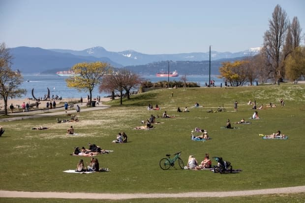 People are pictured in the sun on Sunset Beach in Vancouver, B.C., on Friday. Warm, sunny weather drove many in Metro Vancouver to the outdoors.  (Ben Nelms/CBC - image credit)