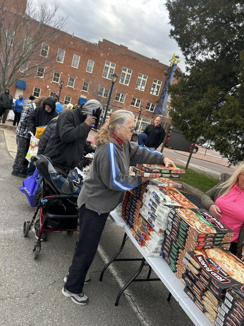 Folks like up Friday, Feb. 2, 2024, in downtown Hopewell for 'Free Food Friday' sponsored by Beacon Hill Church. Each week, hundreds of people come through the line to collect food necessities, and most of them are from unemployed or underemployed families.