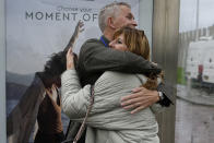 People who lost relatives in the downing of MH17, hug at a bus stop after the court's verdict at Schiphol airport, near Amsterdam, Netherlands, Thursday, Nov. 17, 2022. A Dutch court has convicted two Russians and a Ukrainian of the murders of 298 people who died in the 2014 downing of Malaysia Airlines flight MH17 over Ukraine. One Russian was acquitted for lack of evidence. (AP Photo/Phil Nijhuis)