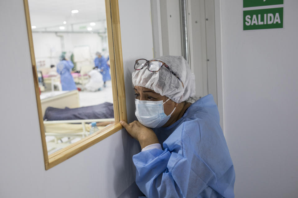 A woman watches as a relative infected with COVID-19 receives supplemental oxygen at the Regional Hospital in Iquitos, Peru, Monday, March 22, 2021. In April 2020, the pandemic hit Peru hard, and Iquitos was struggling with the area's only two hospitals lacking sufficient space to attend COVID-19 patients. (AP Photo/Rodrigo Abd)