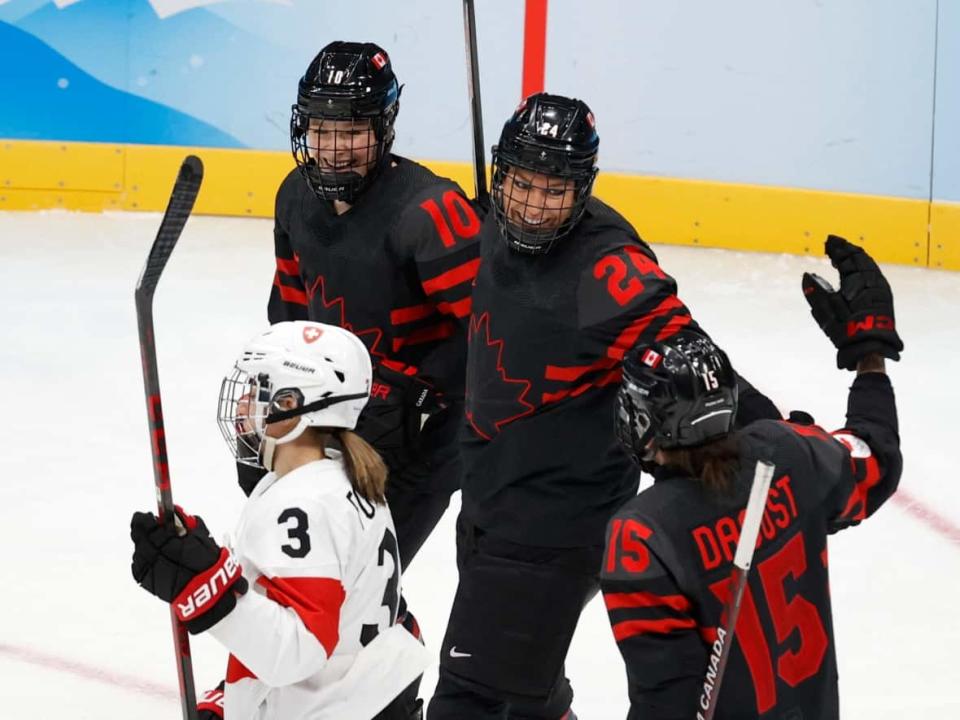Canada's Natalie Spooner, middle, celebrates her first-period goal with linemates Sarah Fillier, left, and Melodie Daoust, right, during the team's 12-1 win over Switzerland on Thursday in China at the Beijing Olympics. (David W. Cerny/Reuters - image credit)