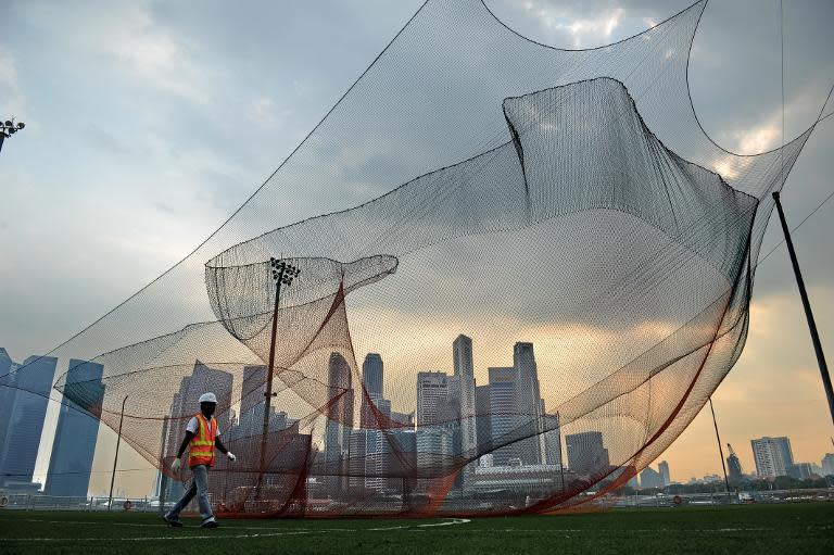 A worker walks past an art installation still under construction in Singapore on March 4, 2014