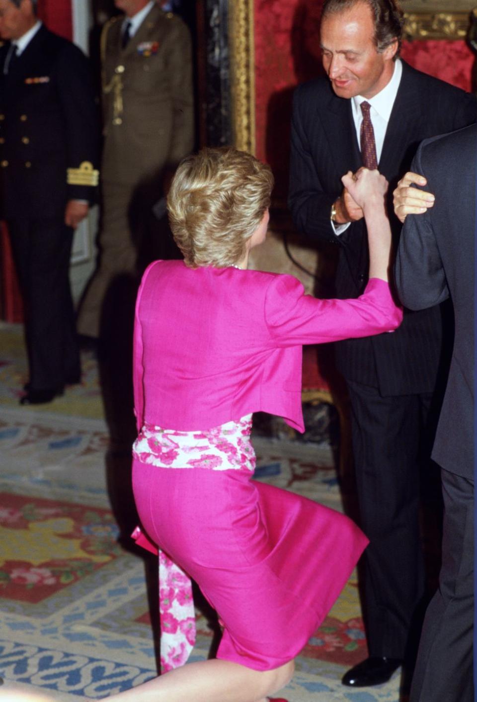 princess diana curtsies to king juan carlos as she arrives a