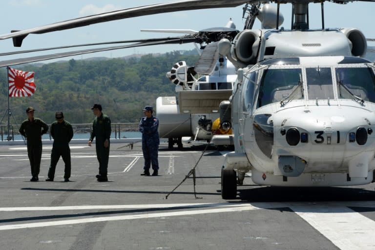 Helicopter crew members of the Japanese helicopter carrier Ise stand on the deck shortly after arriving at the former US naval base, Subic port, north of Manila, on April 26, 2016