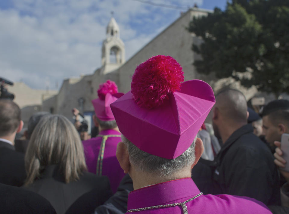 Archbishop Pierbattista Pizzaballa, the top Roman Catholic cleric in the Holy Land, and his entourage arrive at the Church of the Nativity, traditionally recognized by Christians to be the birthplace of Jesus Christ, ahead of midnight Mass after he crossed an Israeli military checkpoint from Jerusalem, in the West Bank city of Bethlehem, Monday, Dec. 24, 2018. Palestinians are preparing to host pilgrims from around the world in celebrating Christmas in the West Bank city of Bethlehem. (AP Photo/Nasser Nasser)