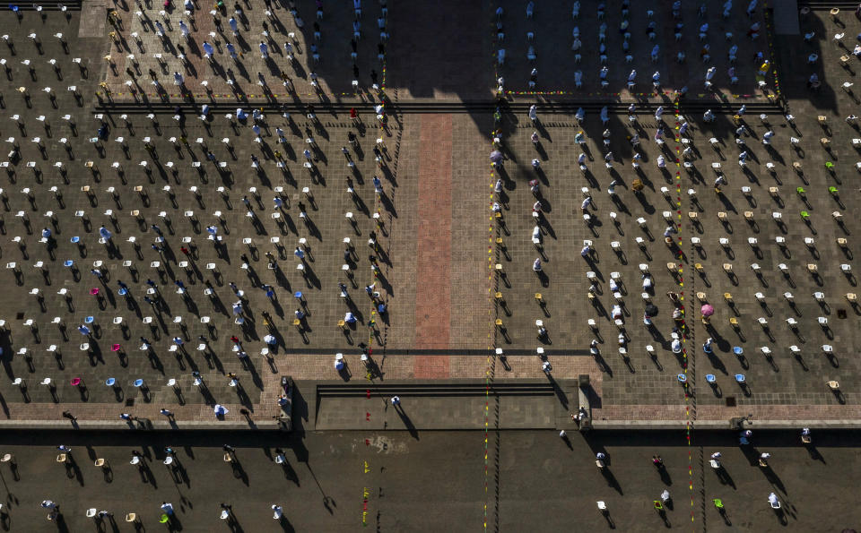 The congregation practices social distancing to curb the spread of the new coronavirus, with chairs arranged a distance apart, as they sit outside and listen to a Sunday morning mass at the Bole Medhane Alem Ethiopian Orthodox Cathedral in Addis Ababa, Ethiopia Sunday, April 5, 2020. The new coronavirus causes mild or moderate symptoms for most people, but for some, especially older adults and people with existing health problems, it can cause more severe illness or death. (AP Photo/Mulugeta Ayene)