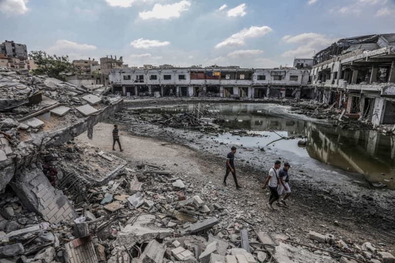 People walk among sewage and rubble of destroyed buildings after the Israeli army withdrew from Khan Yunis. Abed Rahim Khatib/dpa