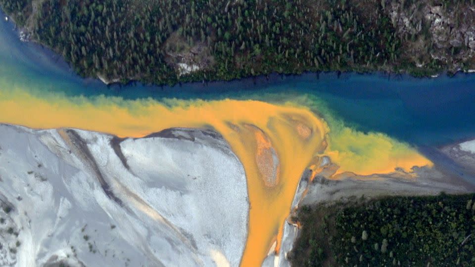 An aerial view of the Kutuk River in Alaska's Gates of the Arctic National Park that looks like<br />orange paint spilling into the clear blue water. - Ken Hill/National Park Service