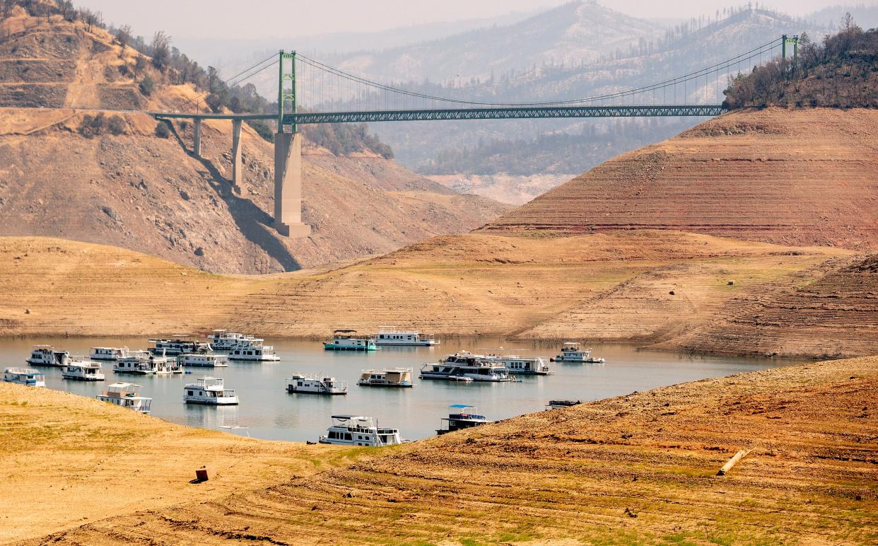 Houseboats sit in a narrow section of water in a depleted Lake Oroville in Oroville, California on September 5, 2021, as the Western U.S. faces drought and excessive heat due to climate change. (Photo by JOSH EDELSON/AFP via Getty Images)