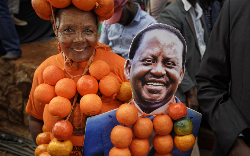 <p>A supporter of opposition leader Raila Odinga wears oranges, the party’s symbol and color, and holds a placard of Odinga, at his final electoral campaign rally in Uhuru Park in downtown Nairobi, Kenya, Saturday, Aug. 5, 2017. (Photo: Ben Curtis/AP) </p>