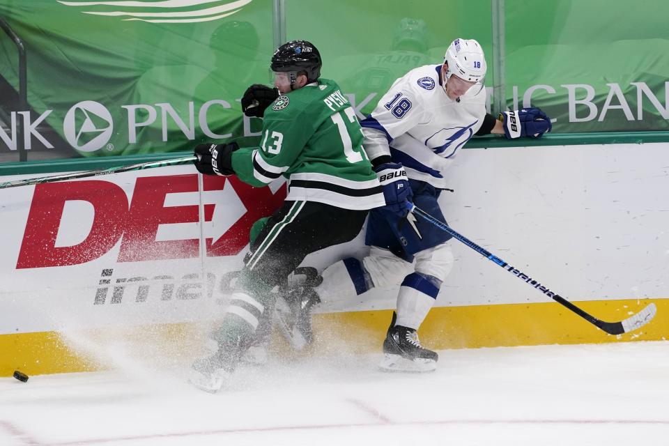 Dallas Stars' Mark Pysyk (13) and Tampa Bay Lightning's Ondrej Palat (18) compete for control of a loose puck in the first period of an NHL hockey game in Dallas, Tuesday, March 2, 2021. (AP Photo/Tony Gutierrez)