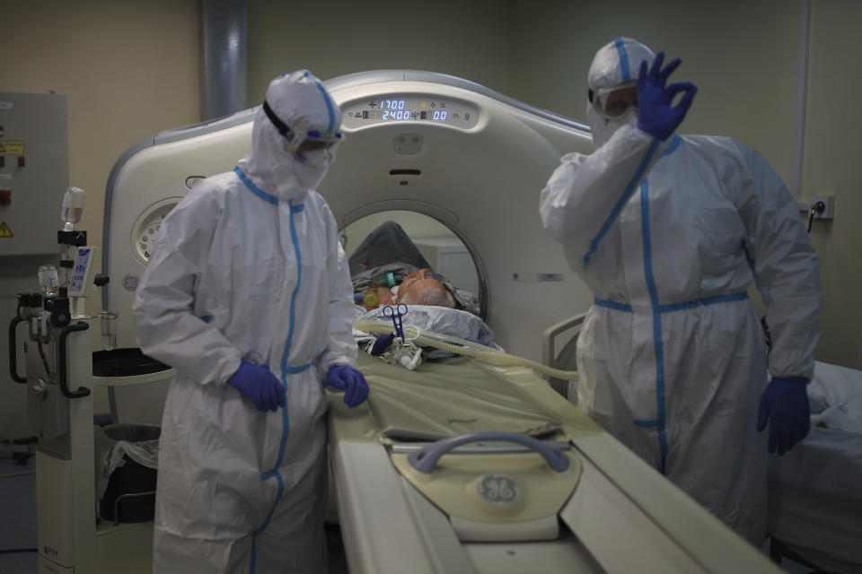 Medical staff members transfer a patient with COVID-19 into a Magnetic resonance imaging system at an ICU of an hospital in Krasnodar, southern Russia, Thursday, Jan. 27, 2022. Russia has confirmed 11,404,617 cases of coronavirus and 328,770 deaths, according to the national coronavirus information center. Russia's total excess fatality count since the start of the coronavirus pandemic is at least 929,000. Under half the population is fully vaccinated. (AP Photo/Vitaliy Timkiv)