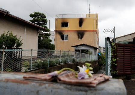 Flowers are placed in front of the torched Kyoto Animation building to mourn the victims of the arson attack, in Kyoto