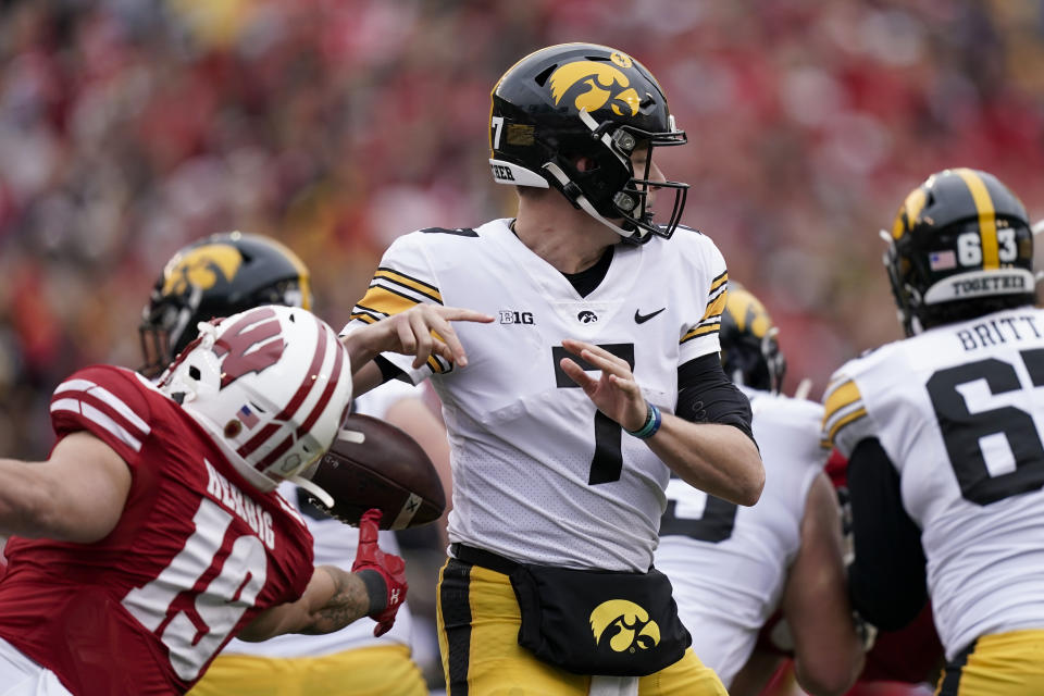 Wisconsin linebacker Nick Herbig (19) forces a fumble against Iowa quarterback Spencer Petras (7) during the first half of an NCAA college football game Saturday, Oct. 30, 2021, in Madison, Wis. (AP Photo/Andy Manis)